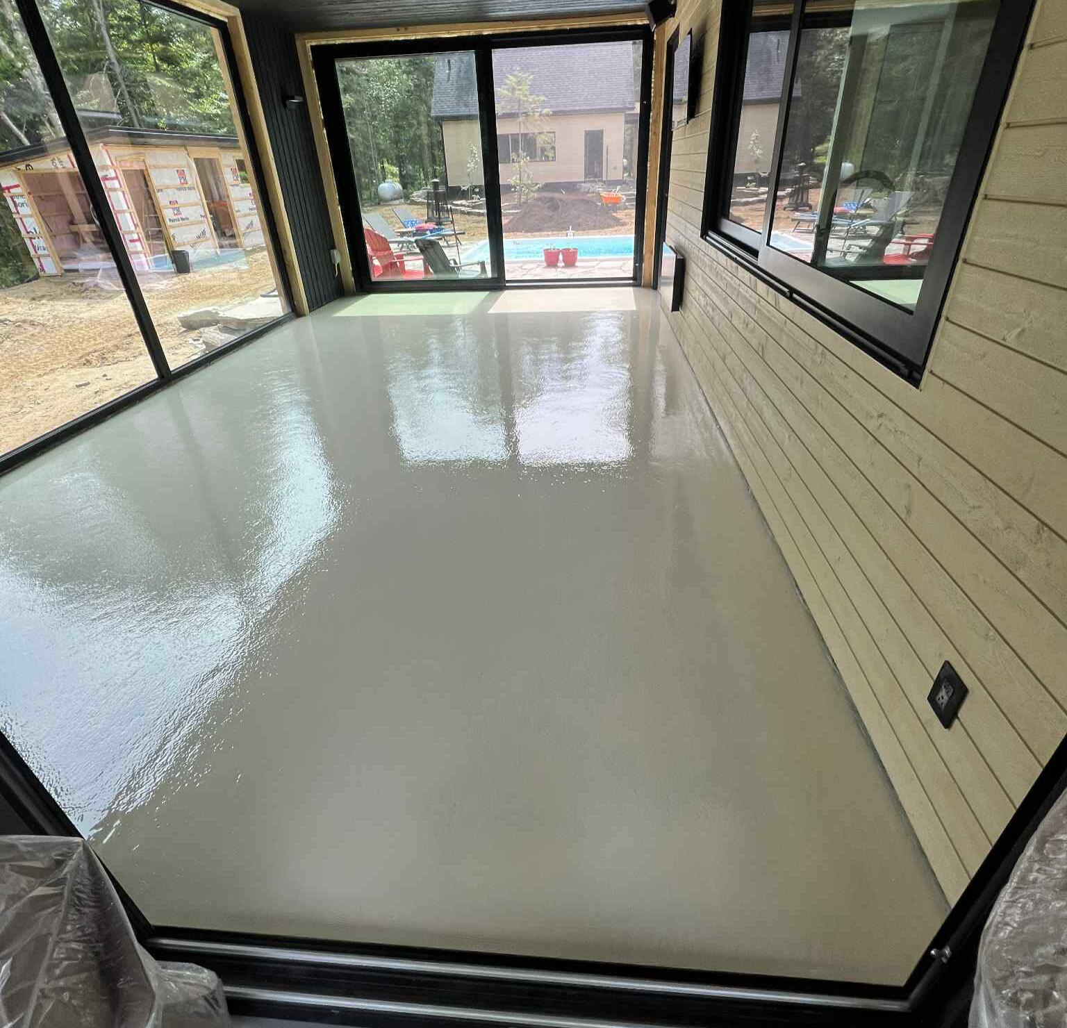 Plancher en époxy beige appliqué dans une pièce résidentielle, offrant une finition durable et facile d’entretien  à Boisbriand